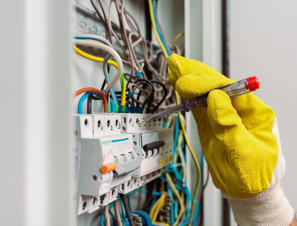 Electrician inspecting wiring to ensure electrical safety and compliance